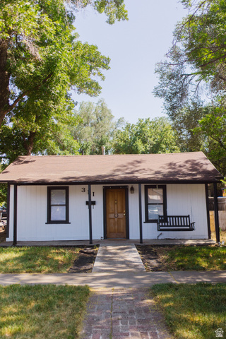 View of front of house with covered porch and roof with shingles