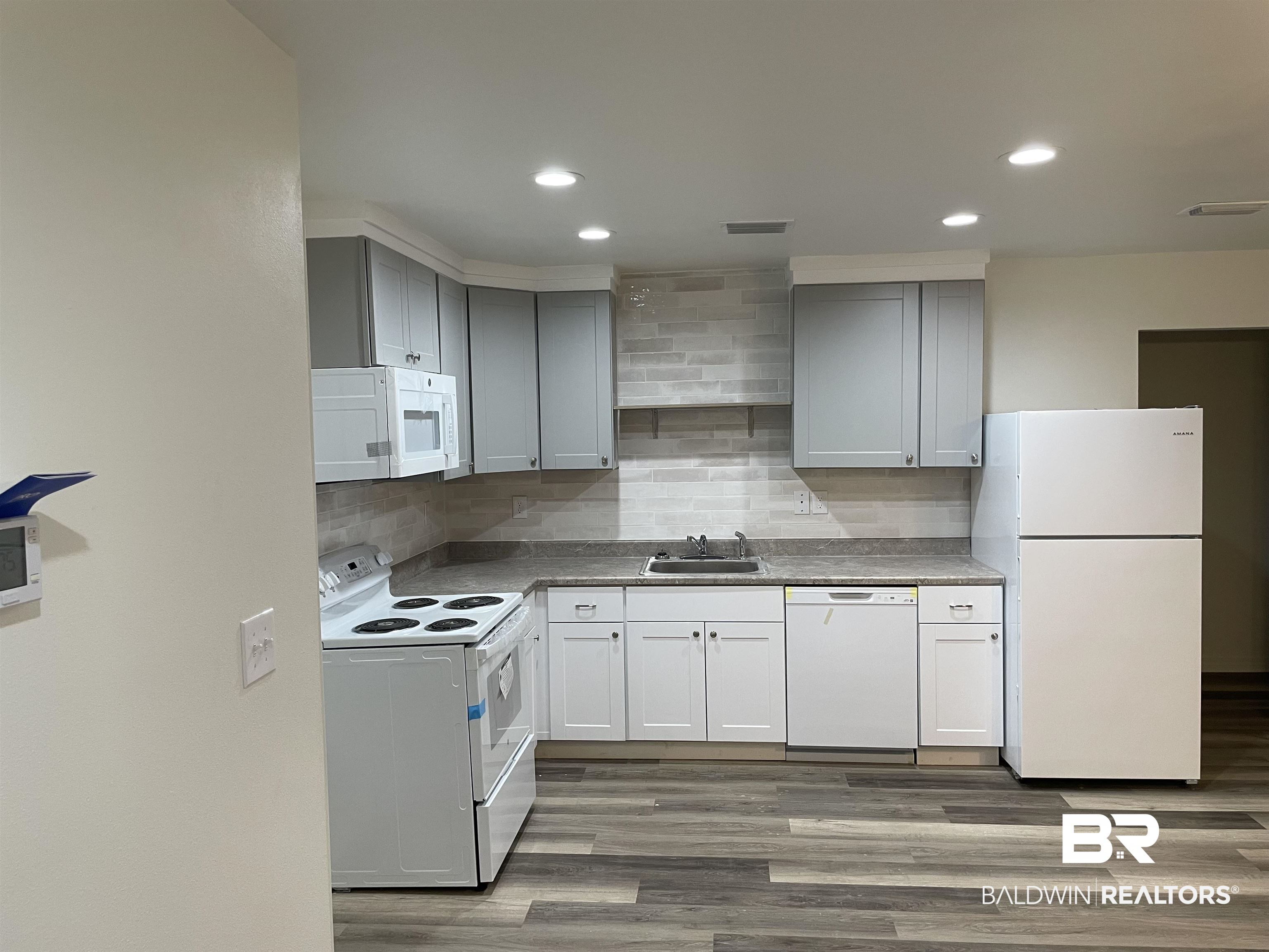 2 Canterberry Circle Foley, AL 36535 - Photo 2 of 24 Kitchen with white appliances, tasteful backsplash, a sink, and wood finished floors