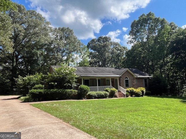 a front view of a house with a yard and green space