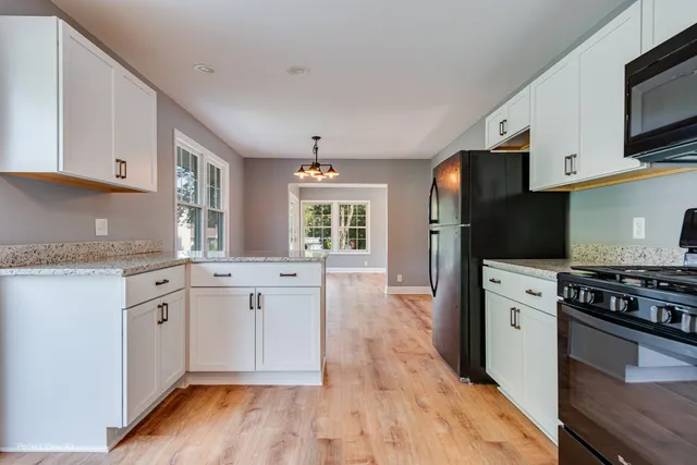 a view of empty room with wooden floor and fireplace