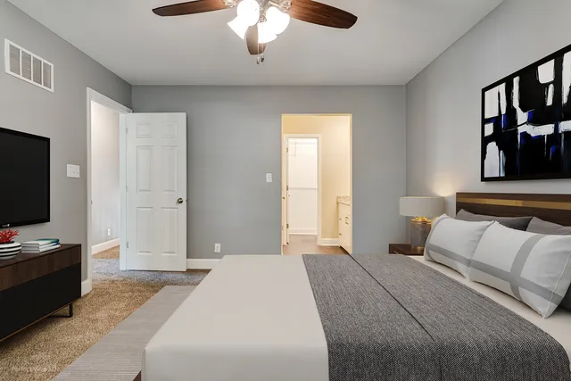 an empty room with windows and chandelier fan
