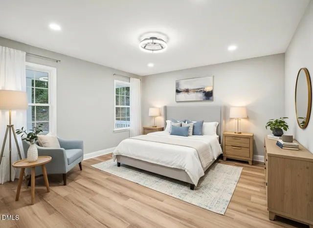 a bedroom with a large bed and windows