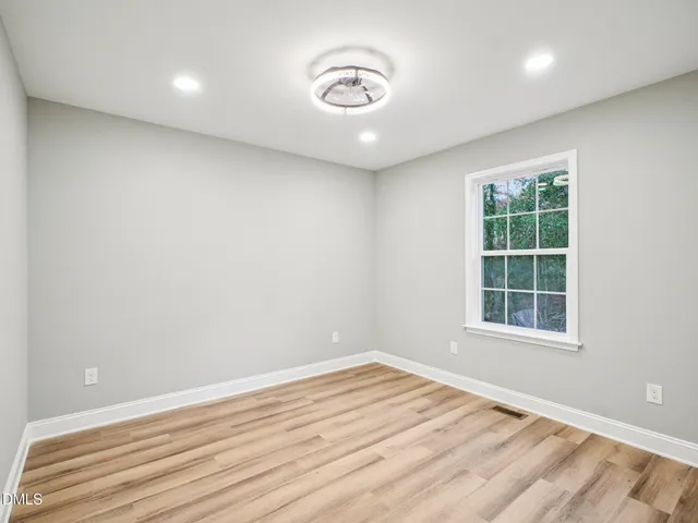 a view of a room with wooden floor and a window
