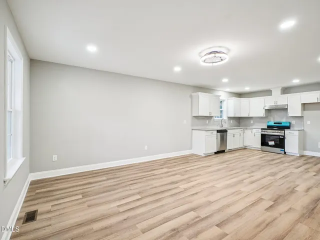 a view of kitchen with kitchen island wooden floor and window
