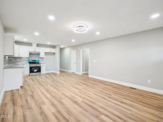 a view of kitchen with kitchen island wooden floor appliances and cabinets