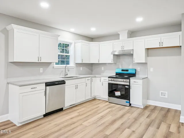 a kitchen with granite countertop white cabinets and stainless steel appliances