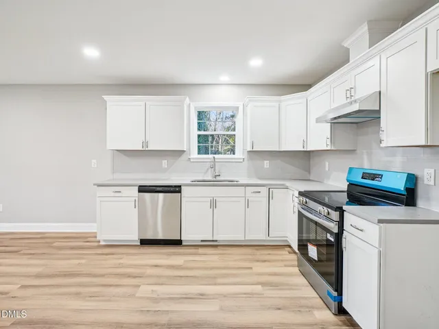 a kitchen with stainless steel appliances granite countertop a stove and a sink