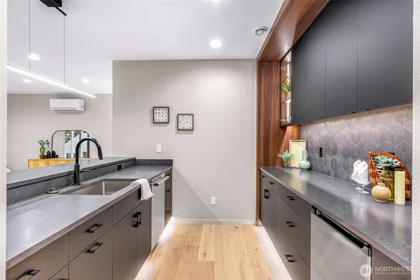 a kitchen with stainless steel appliances a sink and chairs