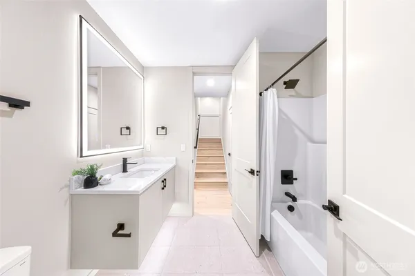 a bathroom with a sink a toilet and shower