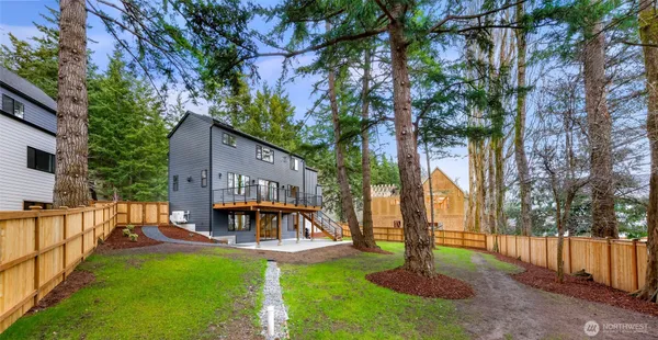 a view of a house with a yard and a large tree