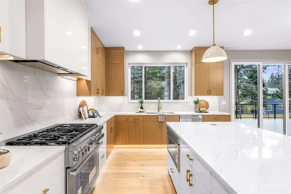 a large kitchen with stainless steel appliances granite countertop a stove and a sink