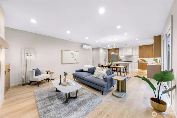 a living room with furniture potted plant and kitchen view