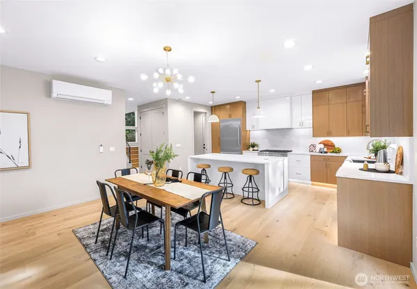 a kitchen with stainless steel appliances kitchen island granite countertop a sink a stove a dining table and chairs