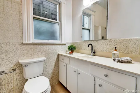 a bathroom with a toilet sink and mirror