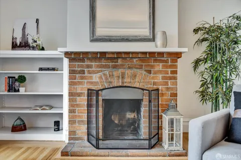 a living room with a fireplace and a potted plant