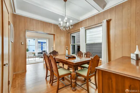 a dining room with furniture a chandelier and wooden floor