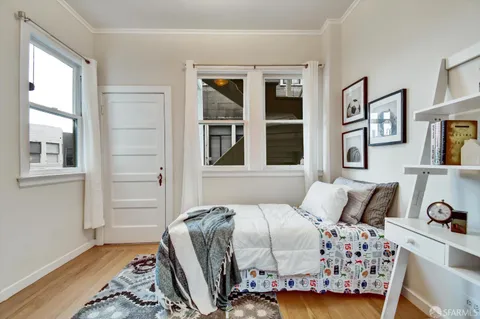 a bedroom with a bed and wooden floor