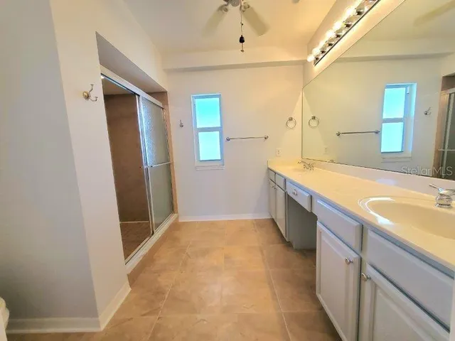 a spacious bathroom with a double vanity sink and a mirror