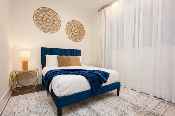 a bed sitting in a bedroom next to a window and a lamp