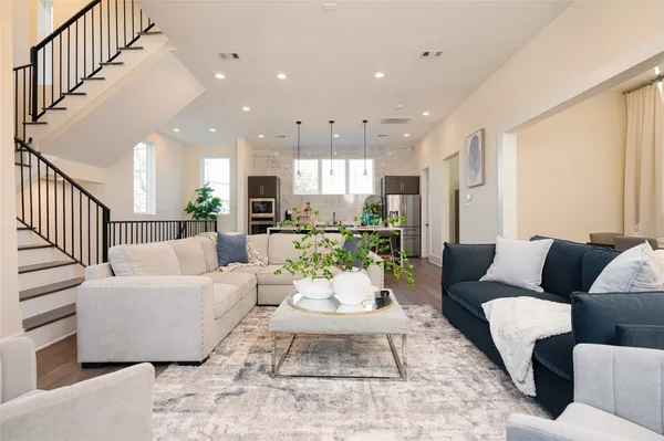 a living room with furniture and a view of kitchen