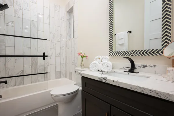a bathroom with a granite countertop sink a toilet and shower