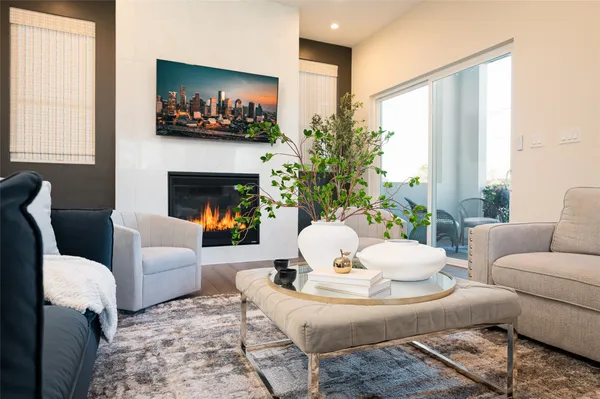 a living room with furniture a fireplace and a large window