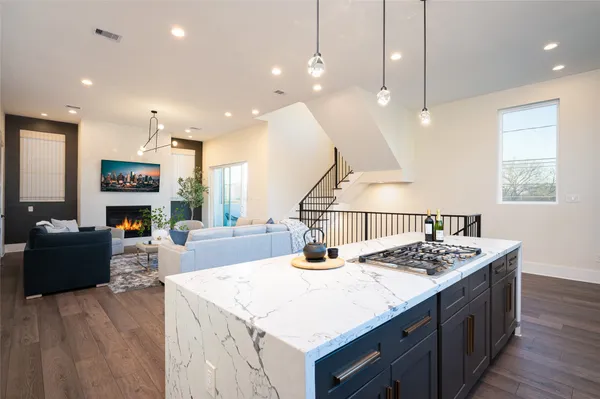 a kitchen with a counter top appliances and a living room view