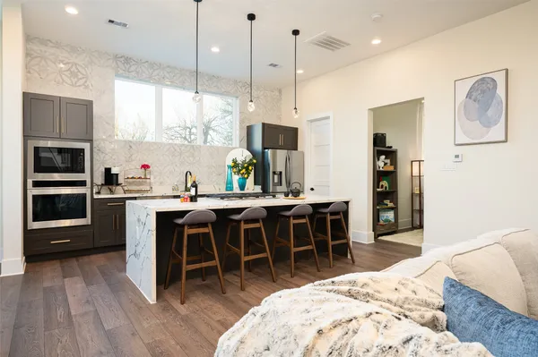 a large kitchen with kitchen island a dining table and stainless steel appliances