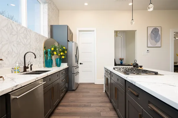 a kitchen with stainless steel appliances granite countertop a sink stove and cabinets