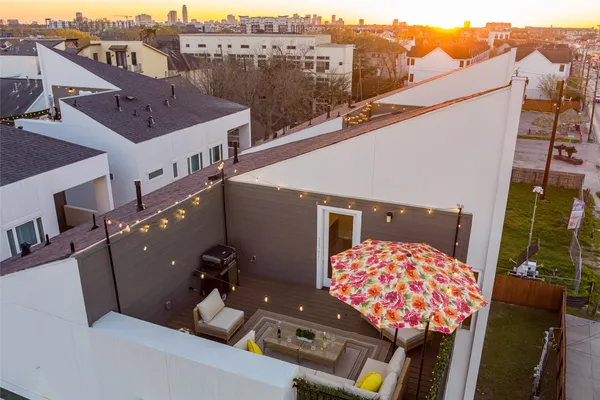 an aerial view of a house roof deck with couches and wooden floor