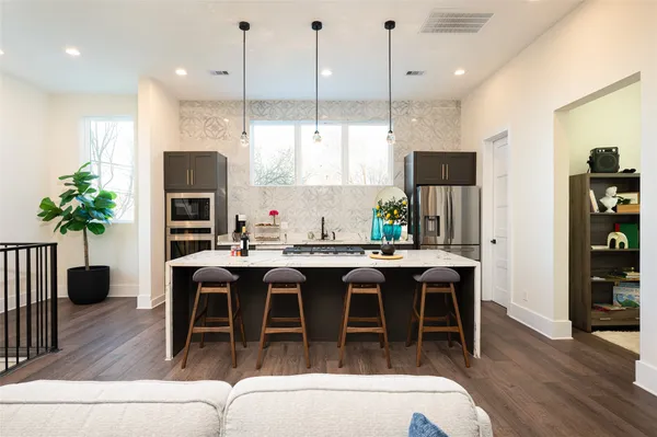 a dining table with stainless steel appliances kitchen island granite countertop a table chairs and a kitchen view