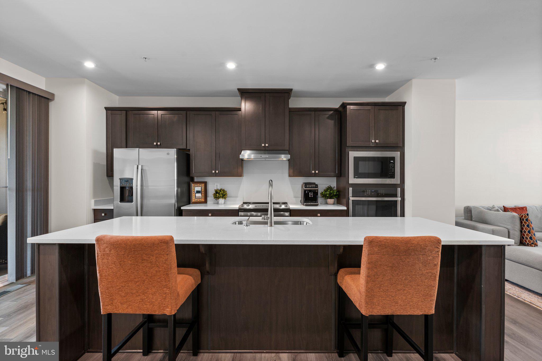 7318 Isabella Road Laurel, MD 20723 - Photo 14 of 39 a kitchen with stainless steel appliances granite countertop a table chairs refrigerator and sink