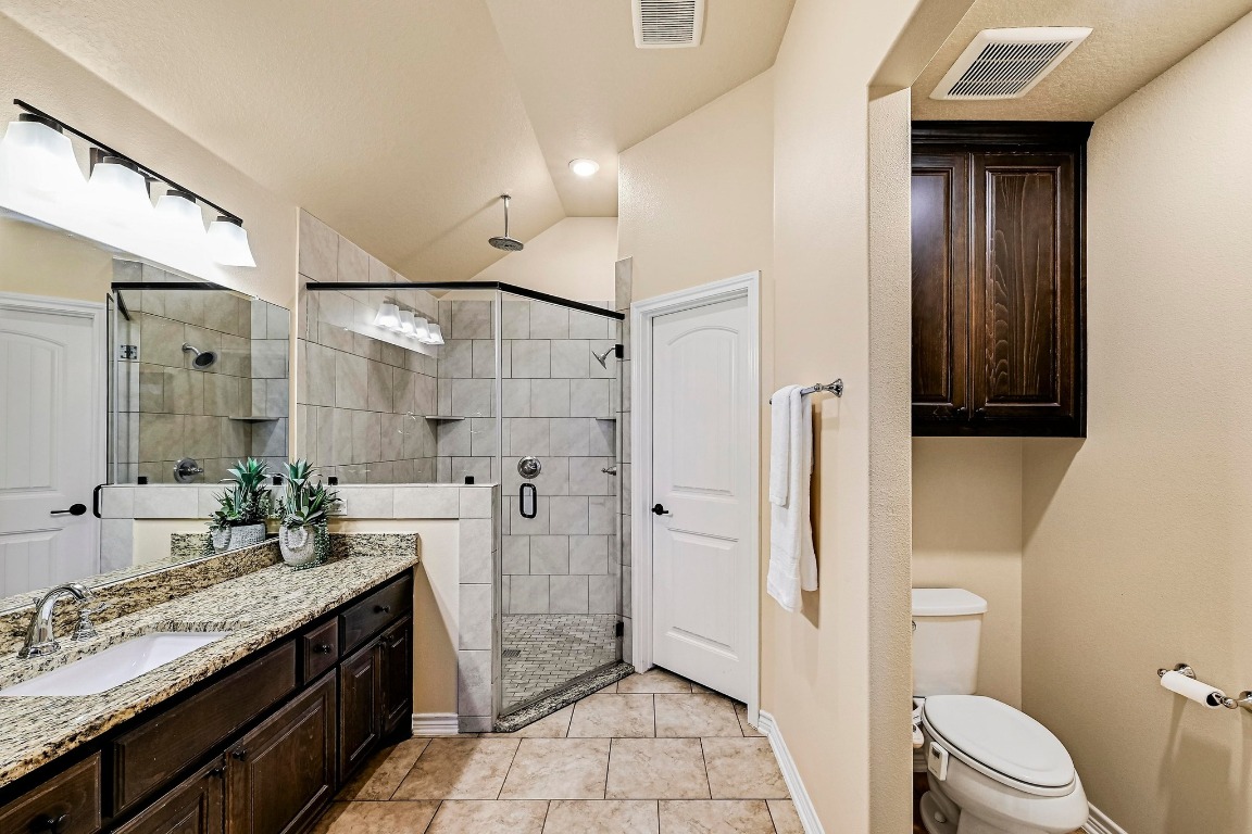 560 Saddle Ridge Drive Bertram, TX 78605 - Photo 12 of 27 a spacious bathroom with a granite countertop sink mirror vanity and toilet