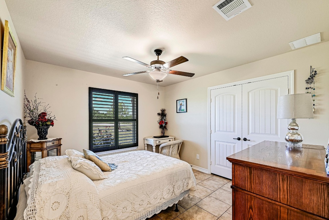 560 Saddle Ridge Drive Bertram, TX 78605 - Photo 14 of 27 a bedroom with a bed and a chandelier