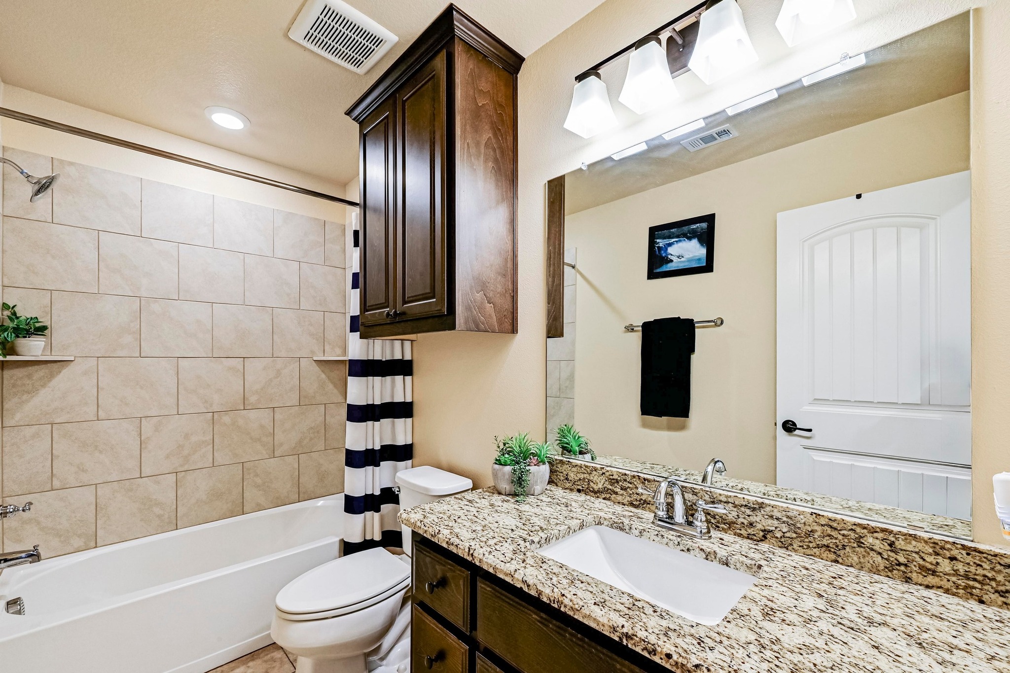 560 Saddle Ridge Drive Bertram, TX 78605 - Photo 15 of 27 a bathroom with a granite countertop sink toilet and shower