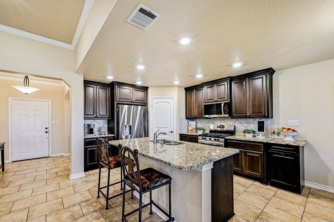 560 Saddle Ridge Drive Bertram, TX 78605 - Photo 9 of 27 a kitchen with a sink and chairs