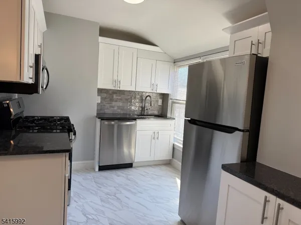 a kitchen with a refrigerator and a stove top oven