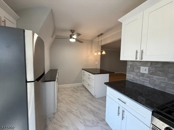 a kitchen with stainless steel appliances granite countertop a sink a stove and a refrigerator