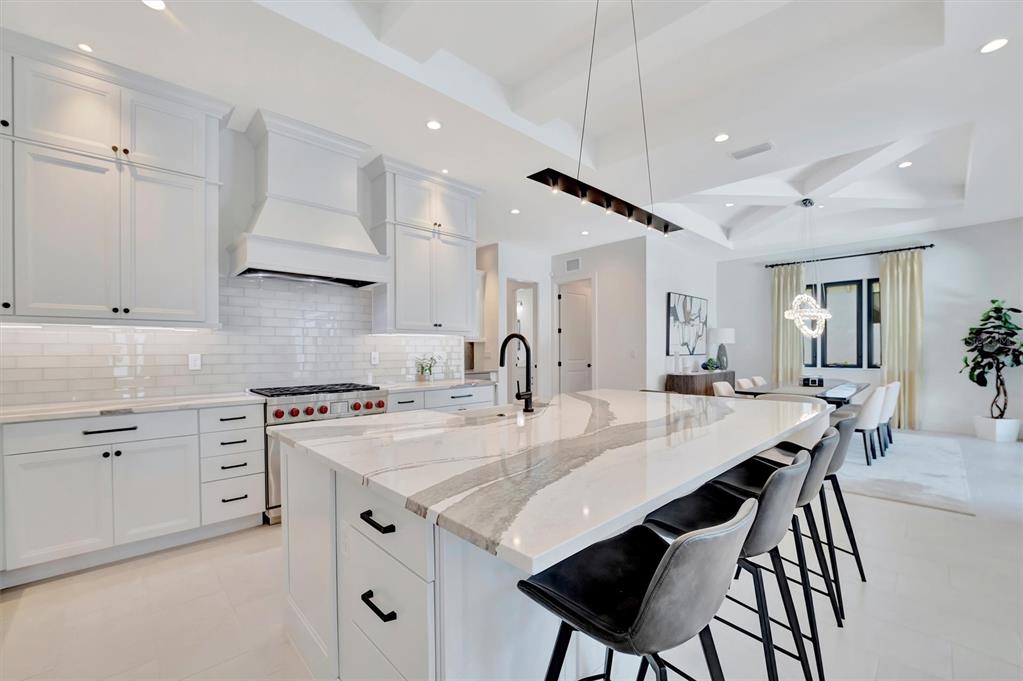 5939 Redbay Boulevard Bradenton, FL 34210 - Photo 19 of 61 a kitchen with a stove a sink a dining table and chairs