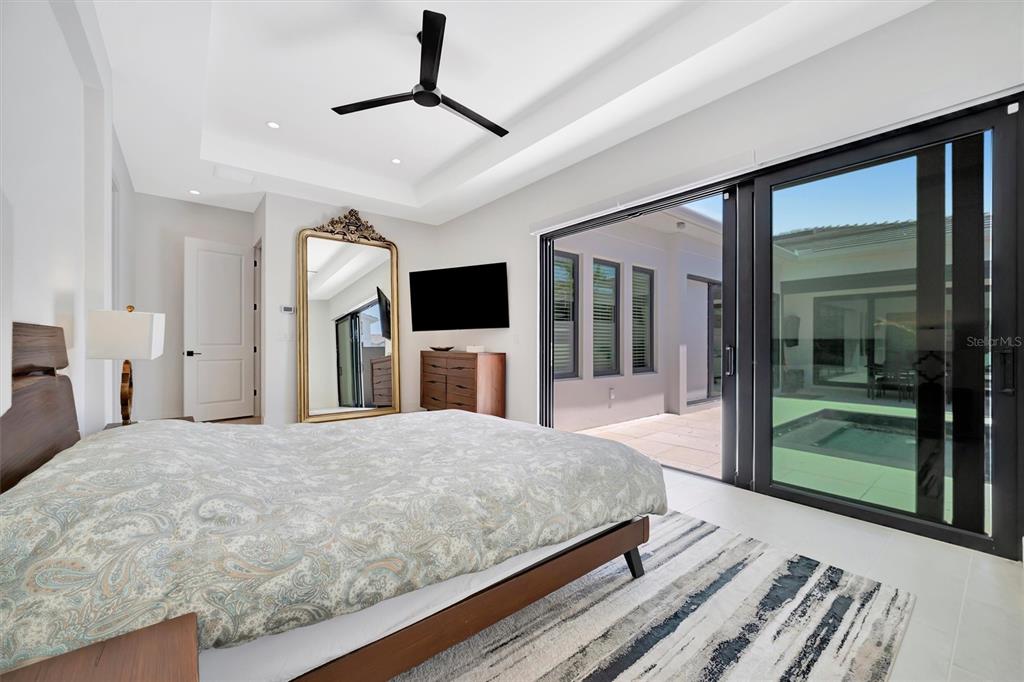 5939 Redbay Boulevard Bradenton, FL 34210 - Photo 33 of 61 a bedroom with a large bed and a flat tv screen