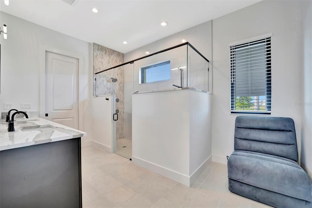 5939 Redbay Boulevard Bradenton, FL 34210 - Photo 35 of 61 a en suite bathroom with a granite countertop sink a mirror and shower