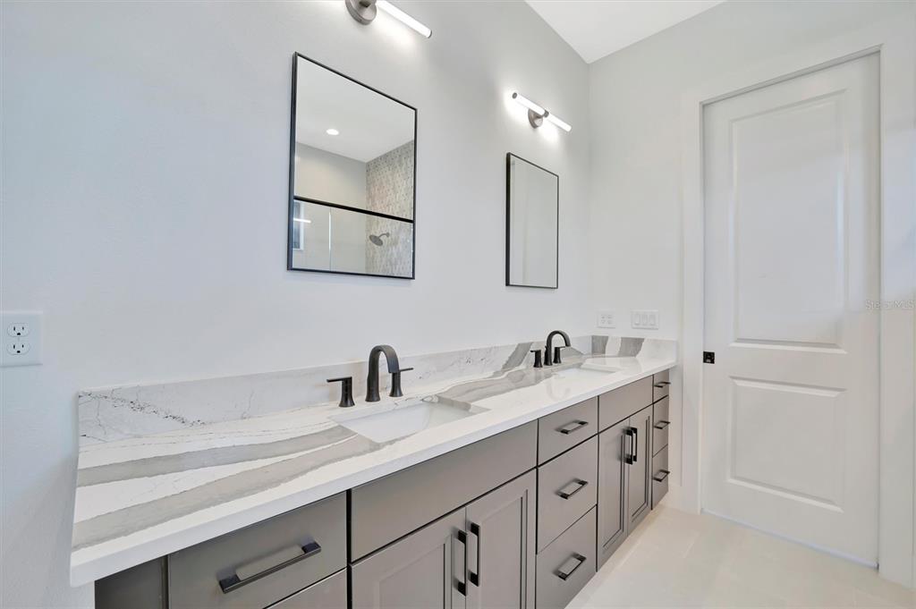 5939 Redbay Boulevard Bradenton, FL 34210 - Photo 39 of 61 a bathroom with a double vanity sink and mirror