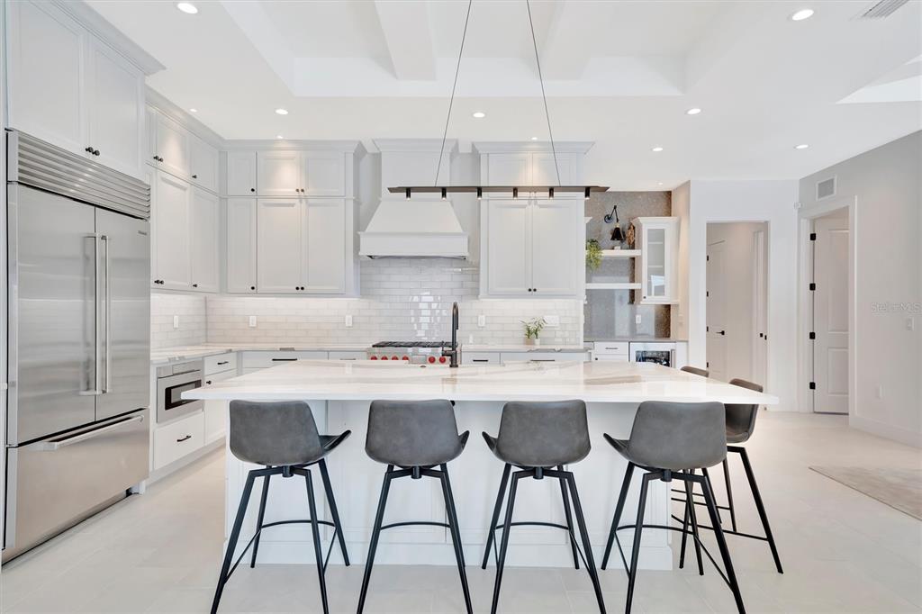 5939 Redbay Boulevard Bradenton, FL 34210 - Photo 10 of 61 a kitchen with stainless steel appliances kitchen island a table chairs in it and white cabinets