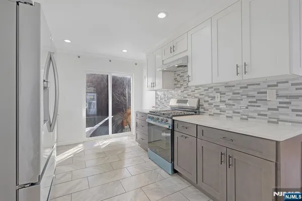 a kitchen with stainless steel appliances granite countertop a refrigerator and a sink
