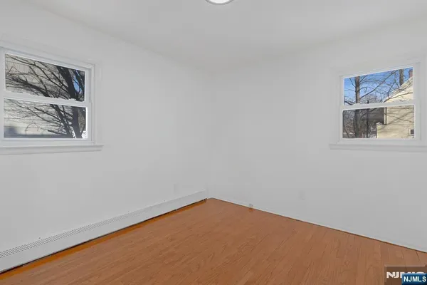 a view of a small space with wooden floor and a window