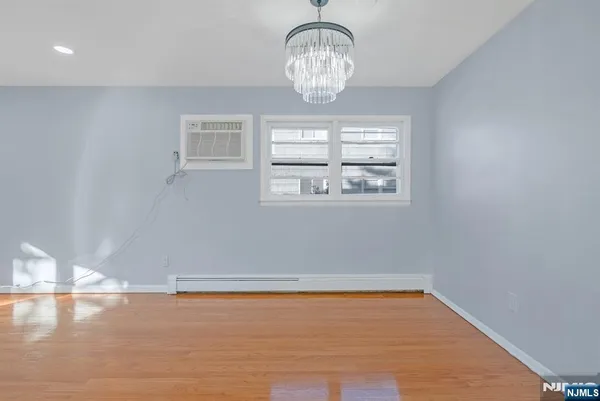 a view of empty room with wooden floor and window