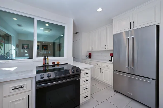 a kitchen with stainless steel appliances granite countertop a refrigerator stove a sink and dishwasher