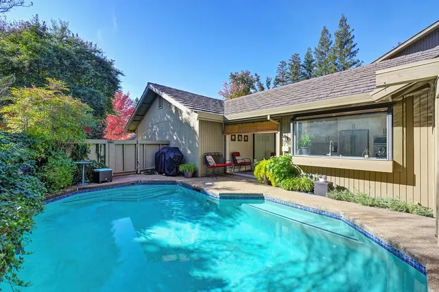 a backyard of a house with barbeque oven table and chairs