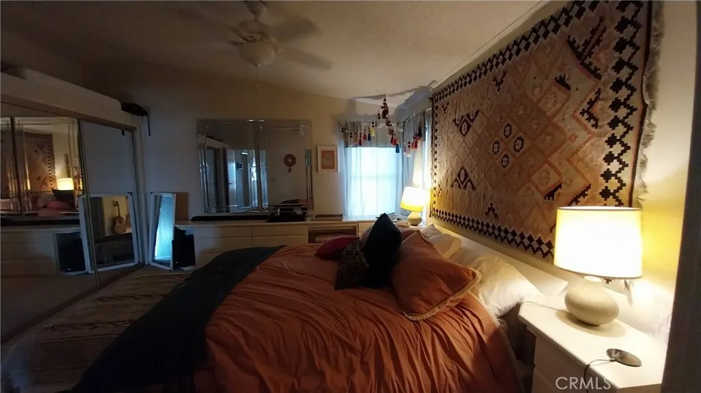 205 Thunderbird Lane, Unit 2 Needles, CA 92363 - Photo 16 of 71 a bedroom with a bed and a mirror