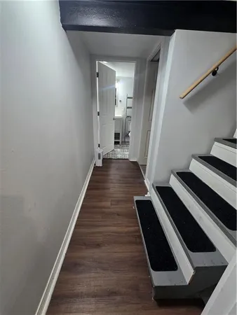a view of a hallway with wooden floor and staircase
